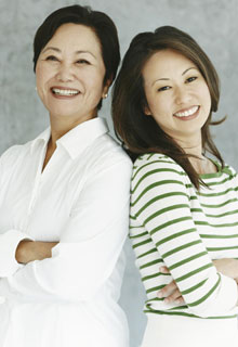Two women smiling while crossing their arms