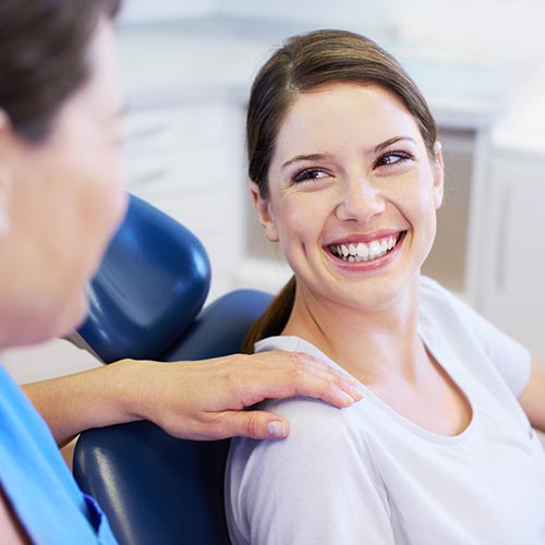 Young woman at the dentist smiling as she waits for her dental treatment