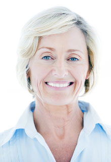 A mature woman with dental implants smiling